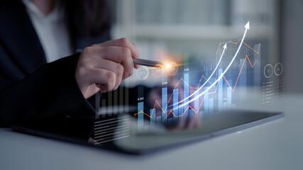A professional businesswoman conducts a financial analysis using a tablet, demonstrating growth metrics and performance trends through innovative technology visuals. Scalp