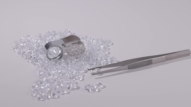 Africa continent from Sparkling cluster of raw uncut diamonds with magnifying loupe and tweezers on white background. Concept African mining industry brilliance.