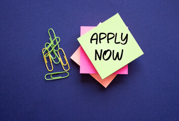 Apply now symbol. Concept word Apply now on sticky note. Beautiful deep blue background. Business...