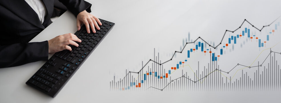 A business professional focuses on financial analysis using a keyboard, showcasing stock market trends and digital graphs in a modern office environment. Scalp - Powered by Adobe