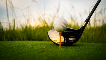Golf ball on green grass in the evening golf course with sunshine background.