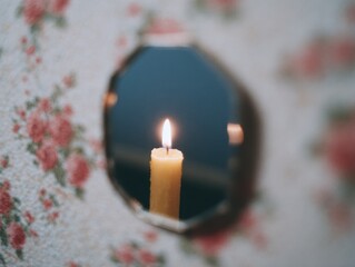 Candle Flame Reflected in Mirror Surrounded by Floral Wallpaper