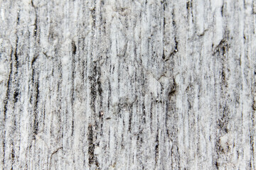 Obraz premium The textured surface of grey stone with a natural grain pattern, displaying intricate details and muted tones, is ideal for use as a background and copy space in design projects.