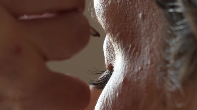 Eyelashes makeup beauty, woman applies false eyelashes to her eyelid, close-up beauty routine