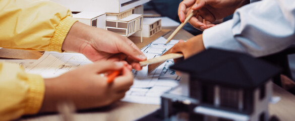 A group of professionals collaborates in an architecture office, engaged in discussing blueprints...