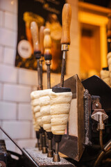 Traditional Czech chimney cakes called Trdelnik baking on rotating metal rods in a Prague street...