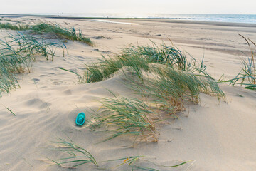 Footpath through dunes with footsteps, tracks in the sand between sedge bushes, footprints on the way, blowing grass in the wind, nobody, a lonely path by the North Sea, solitude