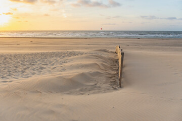 evening light and water makes structures in the sand at the North Sea, natural art on the sandy beach, a stream on the beach forms water and sand, wave-shaped depressions form a beautiful pattern