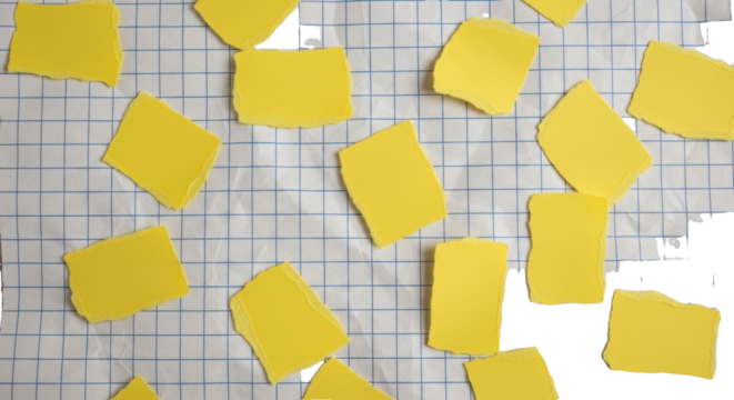 Yellow paper scraps with torn edges on white school checkered paper, background with copy space