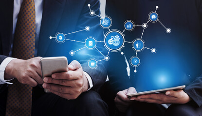 Two business professionals engaged in analyzing key performance indicators on their devices, showcasing modern technology and data visualization in a corporate environment. Tessel