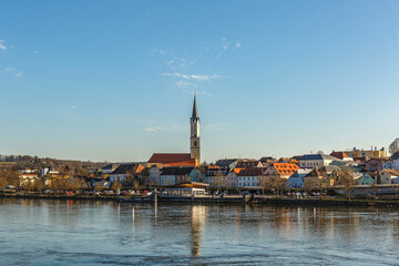 Fototapeta premium Panoramic view of Vilshofen an der Donau with church tower and colorful houses reflected in the river