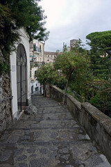 Ripida scalinata in pietra in un tipico vicolo di ravello con vista sul paese e la torre 4349