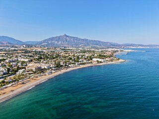 Fototapeta premium aerial view of the coast with beach and promenade with palms in San Pedro de Alcántara in beautiful light, Malaga, Costa del Sol, Andalusia, Spain 