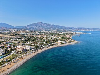 Fototapeta premium aerial view of the coast with beach and promenade with palms in San Pedro de Alcántara in beautiful light, Malaga, Costa del Sol, Andalusia, Spain 