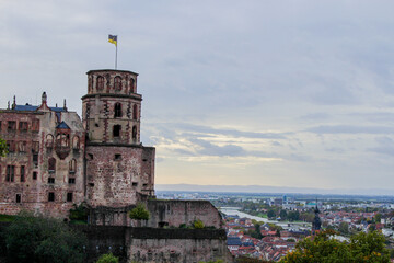 closeup of the heidelberg castle tower and a wide panoramic view of the landscape with the city, river and mountains in the back