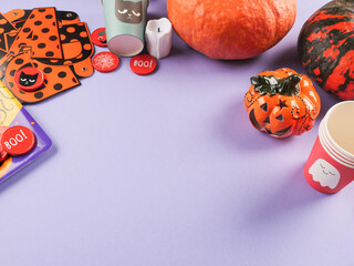 Halloween purple frame background flatlay with pumpkins and party decor