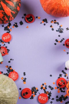 Halloween purple frame background flatlay with pumpkins and party decor