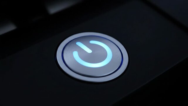 Illuminated power button on a dark surface, equipment activation