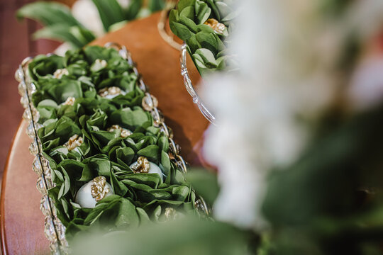 Elegant display of Brazilian walnut wedding sweets ("camafeu de nozes") in green wrappers