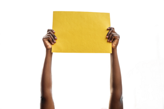 se-up of a hand holding up yellow paper. Cutout. Transparent. Message. Protest. Demonstration. Opinion. Statement.