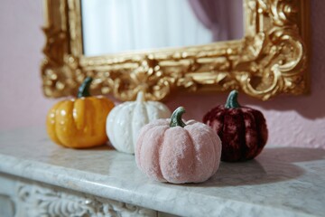 Colorful Decorative Pumpkins on Marble Surface with Golden Mirror