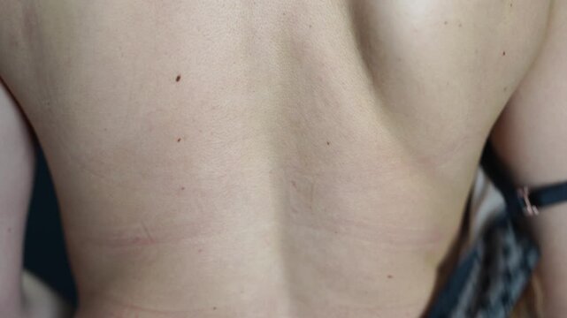 Bra, unfastening, woman unhooking her black lace bra from the back, preparing for an intimate moment