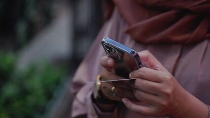 Young asian woman hand holding credit card using a digital mobile device and buying online and internet shopping. Close up of asian female hand typing card number on smartphone. Technology concept. - Powered by Adobe