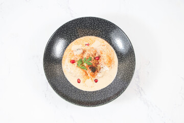 Dahi Baray or bhalla Yogurt Lentil Fritters Garnished with Pomegranate and Spices in bowl isolated on marble background top view