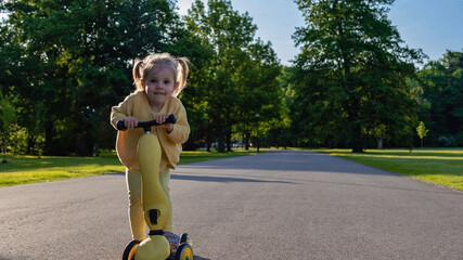Child riding. Scooter toddler park play. Summer road motion casual sport.