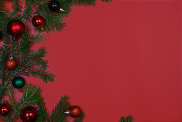 A Beautiful Display of Festive Christmas Ornaments and Pine Branches on a Rich Red Background