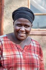 african woman in the village, standing in front of the house, rural life in Botswana