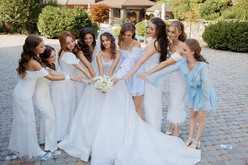 Naklejka premium Group of excited bridesmaids celebrating a wedding outdoors in a beautiful garden setting