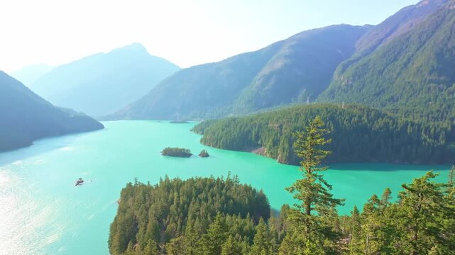 An emerald-hued scenic view of Diablo Lake and the majestic North Cascades mountain range, captured from an elevated perspective