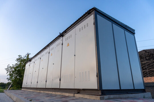 Outdoor industrial electrical power substation building under clear blue sky during daylight