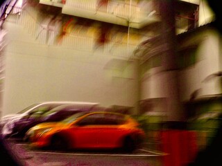 オレンジの車と都市の残像
