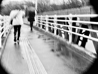 雨の歩道を歩く人々　モノクロの冬景色