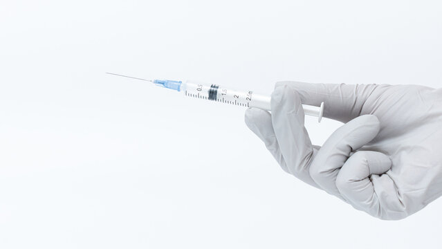 Hand in medical glove holding a syringe filled with botox solution, symbolizing cosmetic treatment and beauty enhancement procedures