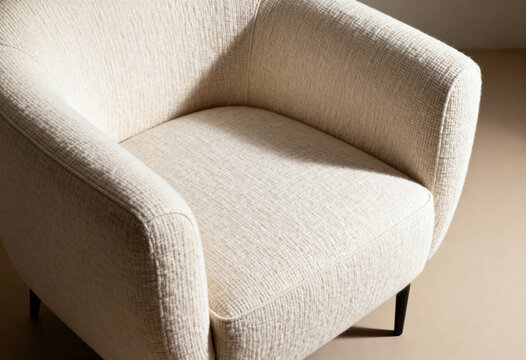 Cotton armchair on neutral surface, close-up furniture studio shot