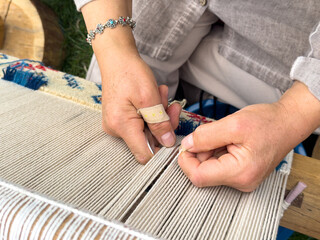 Carpet weaving using traditional techniques on a loom. , close-up of weaving and handmade carpet production.