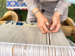 Carpet weaving using traditional techniques on a loom. , close-up of weaving and handmade carpet production.
