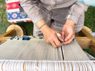 Carpet weaving using traditional techniques on a loom. , close-up of weaving and handmade carpet production.