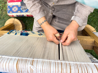 Carpet weaving using traditional techniques on a loom. , close-up of weaving and handmade carpet production.