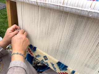 Carpet weaving using traditional techniques on a loom. , close-up of weaving and handmade carpet production.