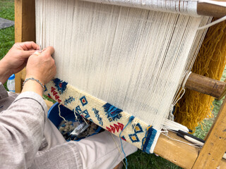 Carpet weaving using traditional techniques on a loom. , close-up of weaving and handmade carpet production.