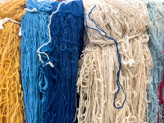 Colorful silk threads for weaving in a textile factory , Cotton color natural dyes handmade, old weaving loom and thread of yarn