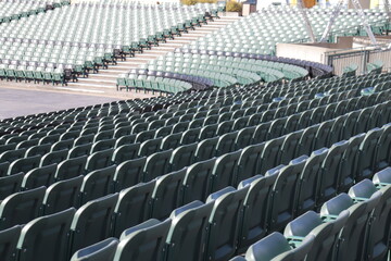 Naklejka premium Rows of seats in stadium and outdoor event in summer. Outdoor architecture and exterior amphitheater with green seats. Seats design and public stadium. Outdoor show in summer.
