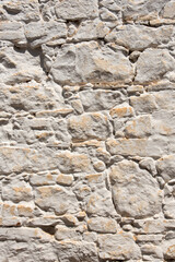 Obraz premium Old white stone wall background. Irregular pattern of antique architectural feature. Sturdy whitewashed house facade in old town, central Spain, Castile-La Mancha. Ancestors culture and craftsmanship.