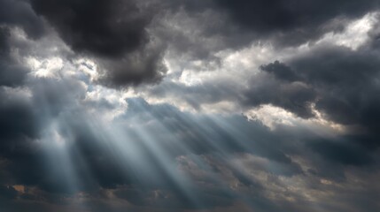 Obraz premium Dramatic Clouds in a Sky with Sunlight Rays Breaking Through Dark Stormy Atmosphere Creating a Stunning Natural Light Display