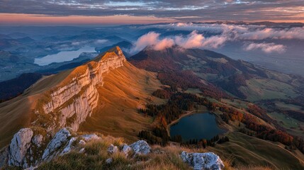 Fototapeta premium Sunrise illuminates mountainous landscape with lake, clouds, and autumn colors