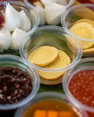 Close-up of traditional Indonesian serabi pancakes served with various sweet porridges such as mung bean, tapioca pearl, and coconut milk